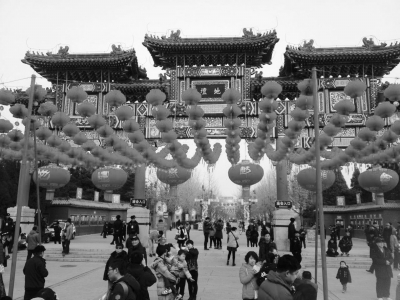 昨天，一早来到地坛庙会的游客在庙会入口处喜庆的灯笼背景下拍照。京华时报读者 刘千越 供图
