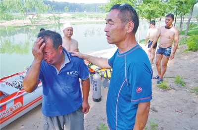 溺水男子的家属痛哭不已，救援队员在旁边安慰。