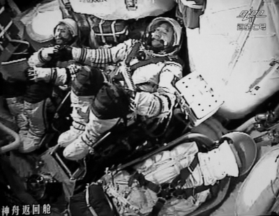 航天员景海鹏（右）和陈冬在任务节点顺利完成后相互握手。