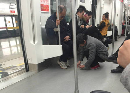 南昌：大妈在地铁上捡拾鞋底掉落泥土
