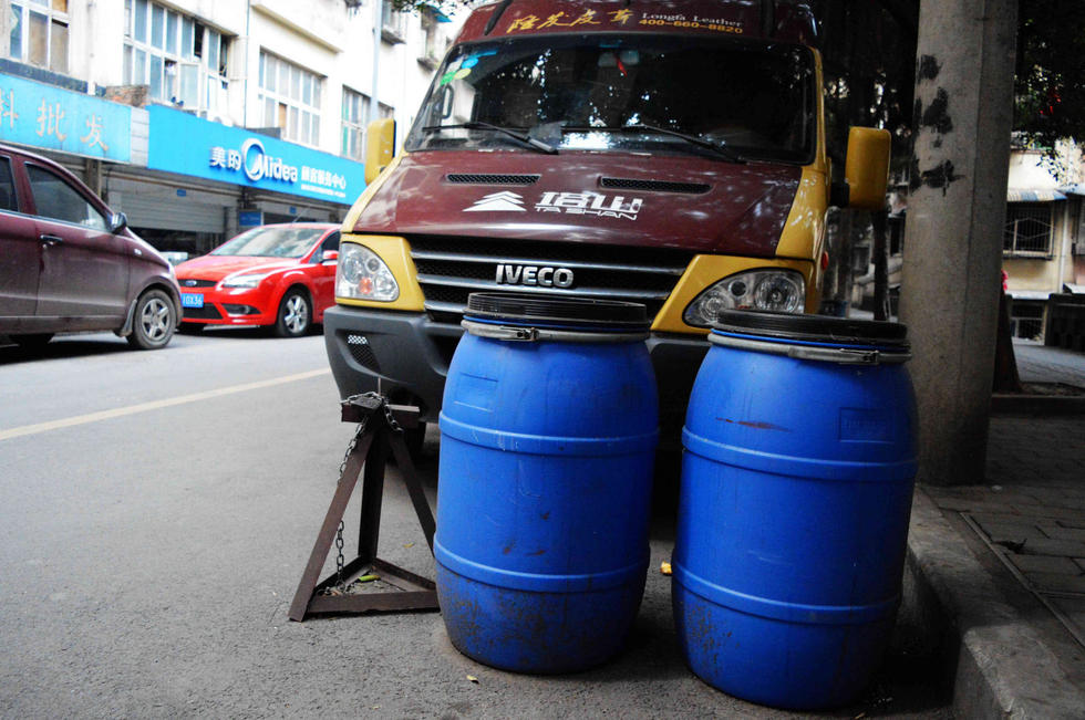 重庆居民自制“神器”占车位 泔水桶桌子齐上阵