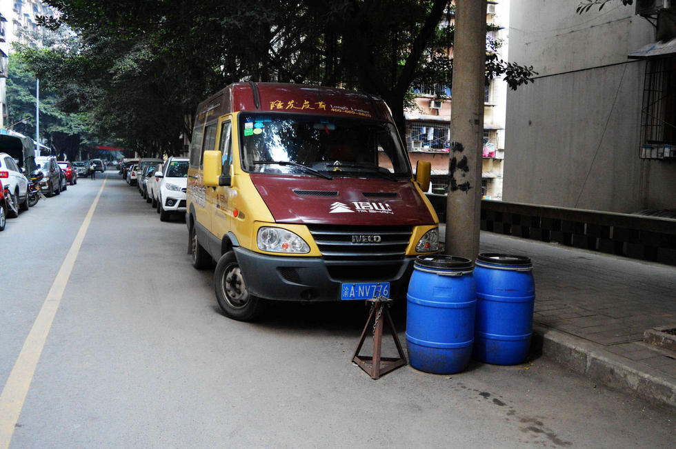 重庆居民自制“神器”占车位 泔水桶桌子齐上阵