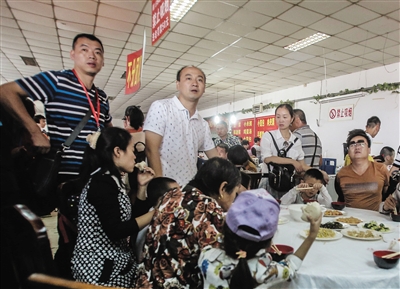 10月3日，在十三陵附近某饭店，旅行团的游客站着等待其他游客吃完，再就餐。