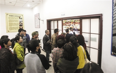 10月24日，在十三陵附近的玉器商场，解说员打开一扇原本紧闭的大门，带领游客进入商场购物。