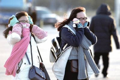 昨天，两位游客“全副武装”迎着寒风在天安门广场游玩。新华社发