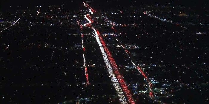 美国ABC7 Eyewitness News用航拍机拍下这一幕：一侧是前灯的白，一侧是尾灯的红，一白一红更像是为圣诞节预热。