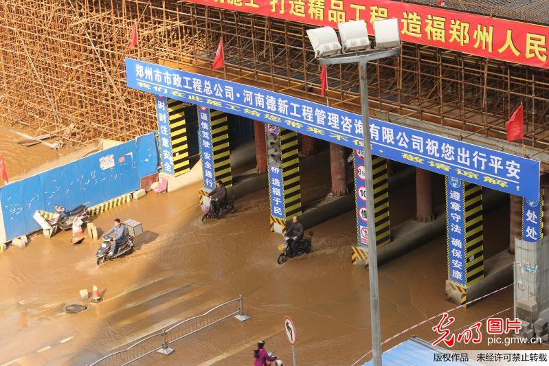郑州街头水管爆裂喷涌如潮 过往路人赤脚通行
