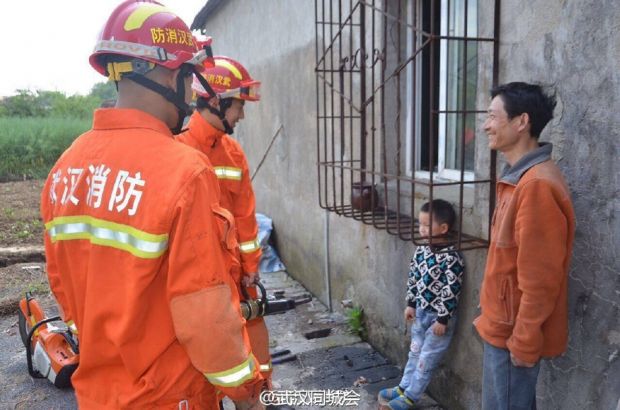 4月11日，武汉江夏区，5岁的小姜玩耍时不小心将头卡在窗户防盗网，动弹不得，父亲面对困境束手无策，急忙求助消防官兵。在消防救助过程中，姜父看着淘气的儿子，突然笑了：“看你以后还乱钻不！”