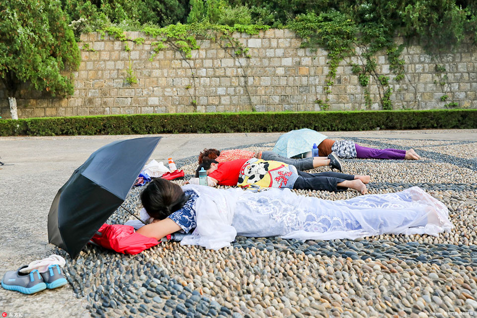 大妈三伏天尬躺广场做"石疗" 惬意晒日光如同身在马尔代夫