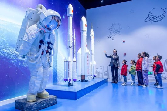 △2026年4月23日，甘肃张掖，孩子们在科技馆航天科普展厅近距离参观长征系列火箭模型。