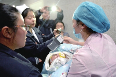 巴掌宝宝被送到八一儿童医院治疗，医院护士正在验明身份，接收孩子进入病房。京华时报记者谭青摄